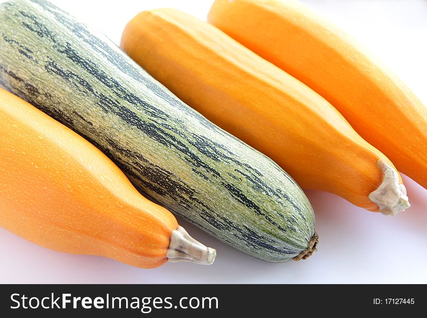 One green and three yellow fresh zucchini (courgettes) isolated on white background. One green and three yellow fresh zucchini (courgettes) isolated on white background