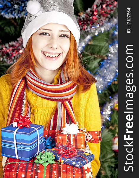 Funny girl in christmas cap with gift boxes