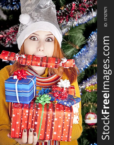 Funny girl in christmas cap with gift boxes