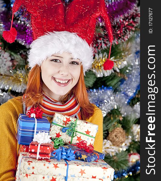 Funny girl in christmas cap with gift boxes