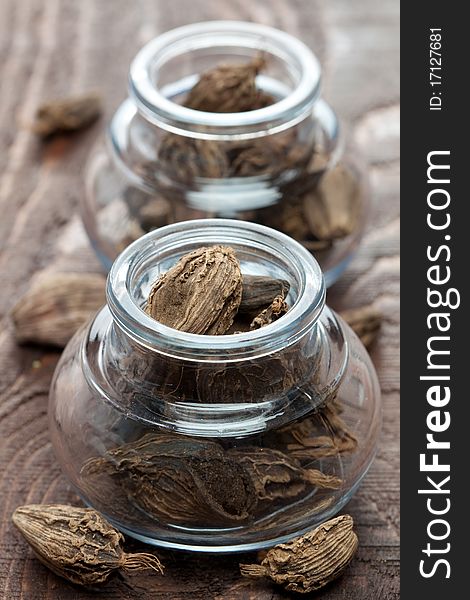 Black cardamom in a glass on wooden table