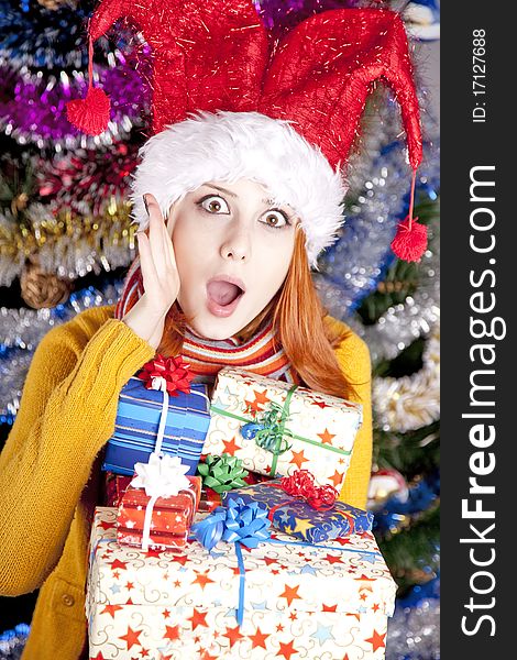 Funny girl in christmas cap with gift boxes
