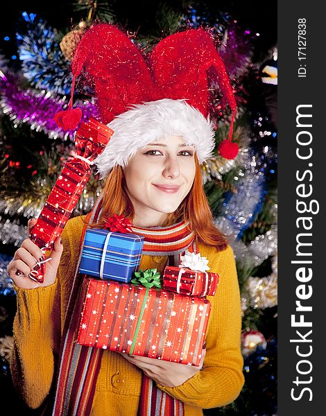 Funny girl in christmas cap with gift boxes