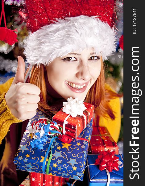 Funny girl in christmas cap with gift boxes