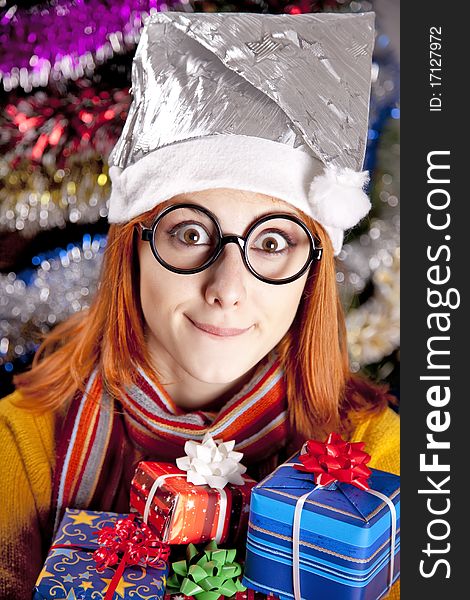 Funny girl in christmas cap with gift boxes