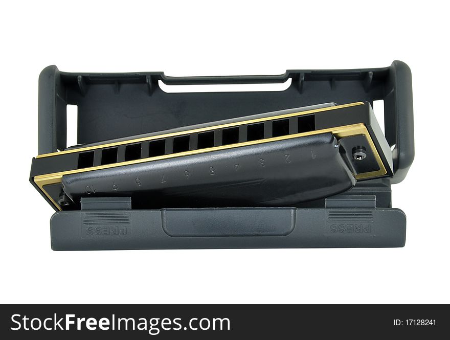 A black and brass blues harp in it's black plastic case. Isolated on a white background. The Blues harp is used in Blues music and sometimes in Country music. A black and brass blues harp in it's black plastic case. Isolated on a white background. The Blues harp is used in Blues music and sometimes in Country music.