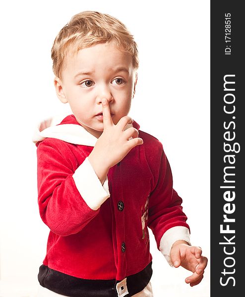 Little boy in Santa's costume touches his nose. Little boy in Santa's costume touches his nose
