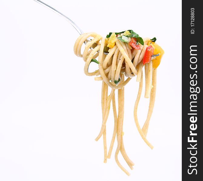 Spaghetti with vegetables on a fork on white background. Spaghetti with vegetables on a fork on white background