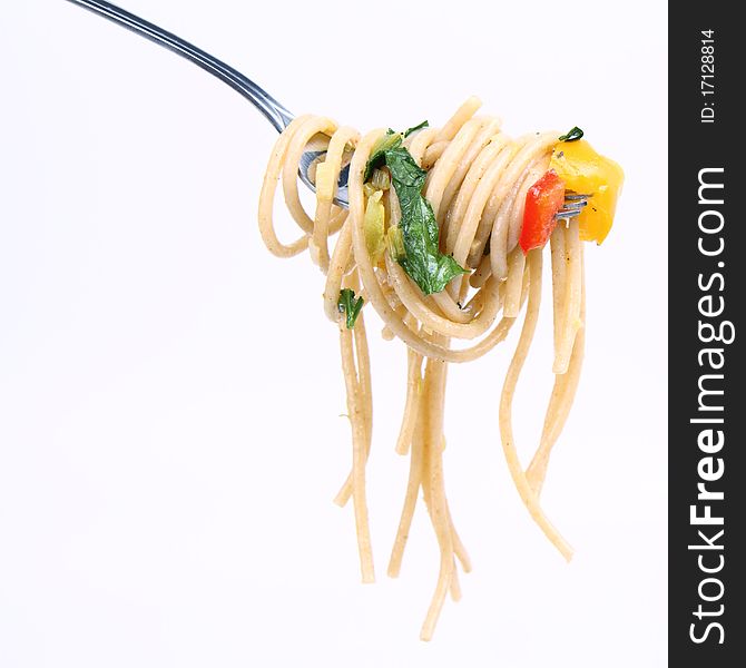 Spaghetti with vegetables on a fork on white background. Spaghetti with vegetables on a fork on white background