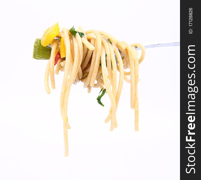 Spaghetti with vegetables on a fork on white background