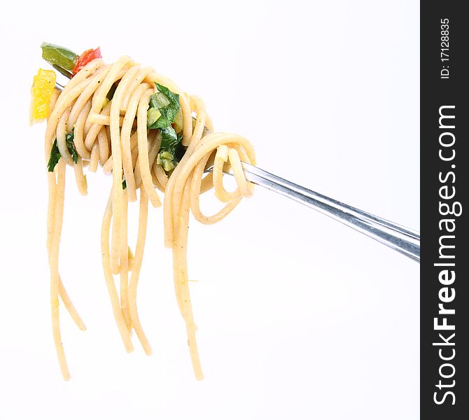 Spaghetti with vegetables on a fork on white background