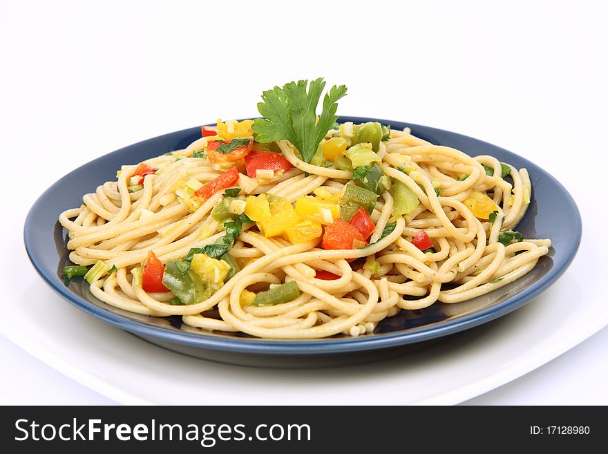 Spaghetti with vegetables on a plate on white background