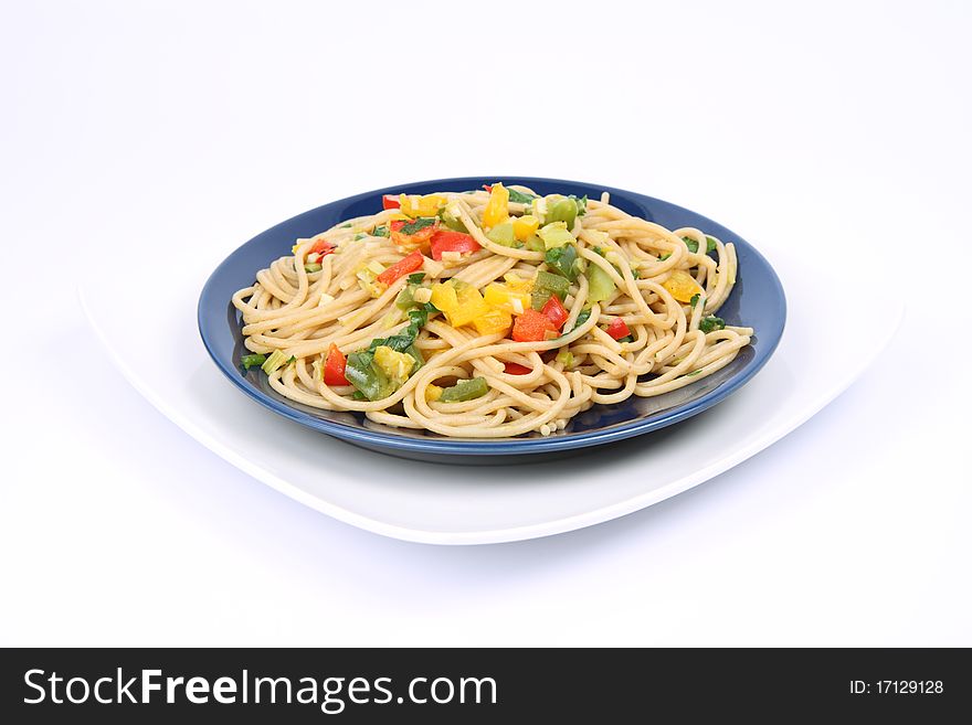 Spaghetti with vegetables on a plate on white background