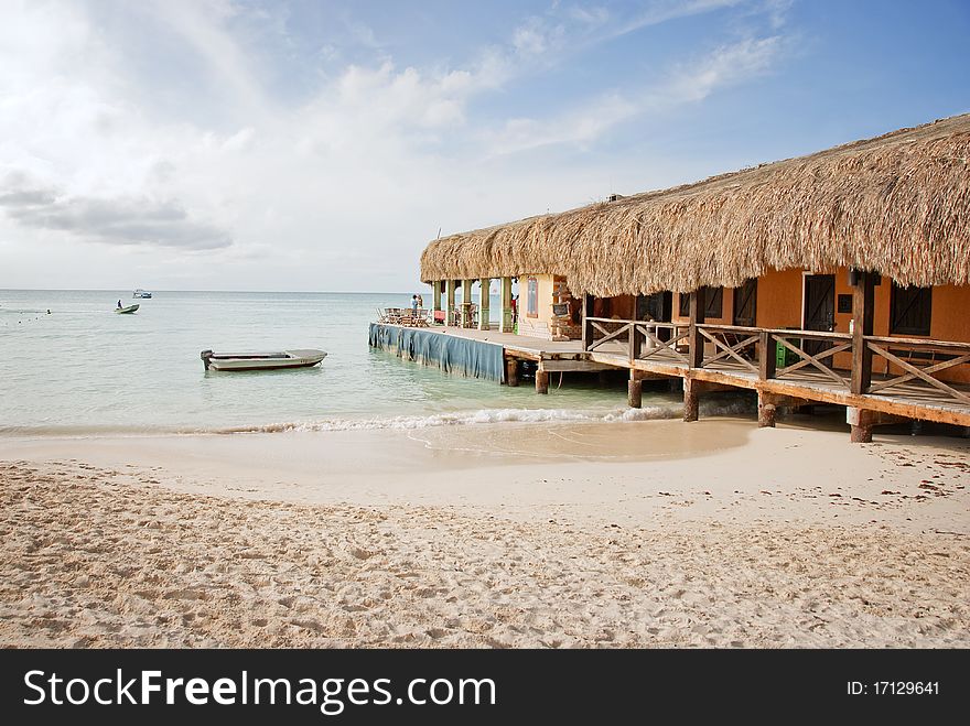 A beach bar with a thatched roof in the Caribbean. A beach bar with a thatched roof in the Caribbean.