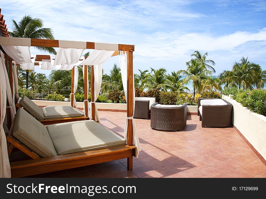 Two cabana beds on the roof overlooking the ocean in the tropics. Two cabana beds on the roof overlooking the ocean in the tropics.