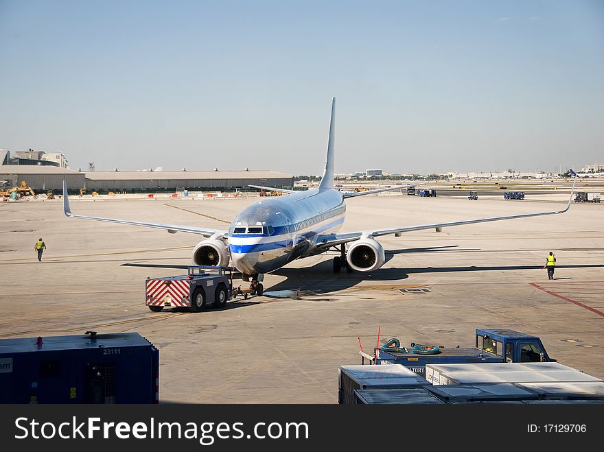 A silver jet airplane on the tarmac of an airport. A silver jet airplane on the tarmac of an airport.