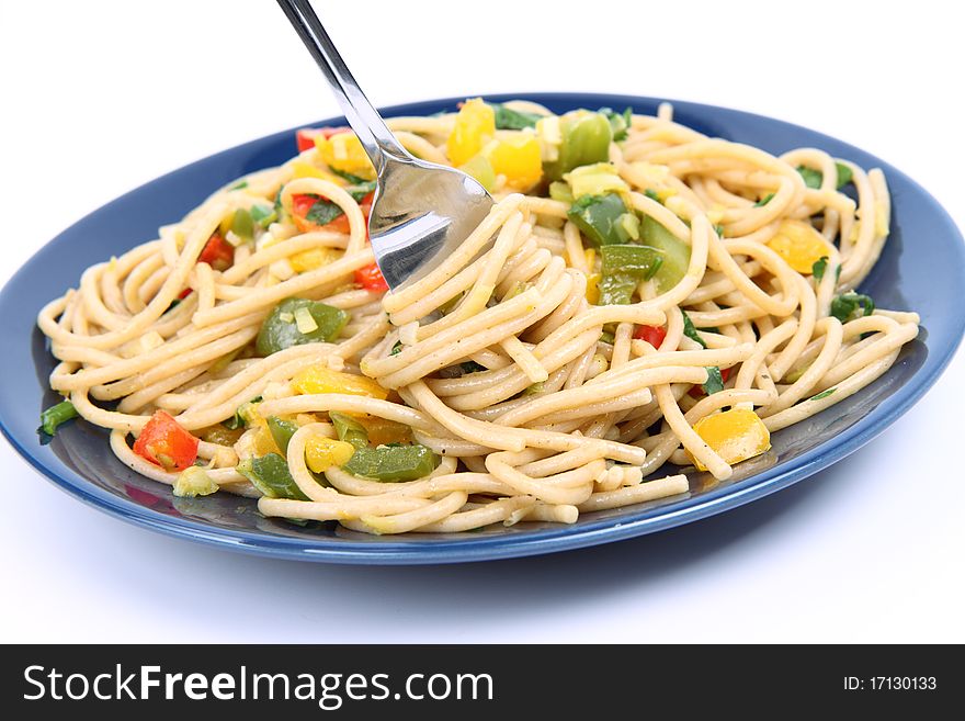 Spaghetti with vegetables being eaten with a fork on white background