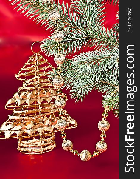 On a red background with a spruce twig Christmas decoration ball on a string of candlesticks. On a red background with a spruce twig Christmas decoration ball on a string of candlesticks.