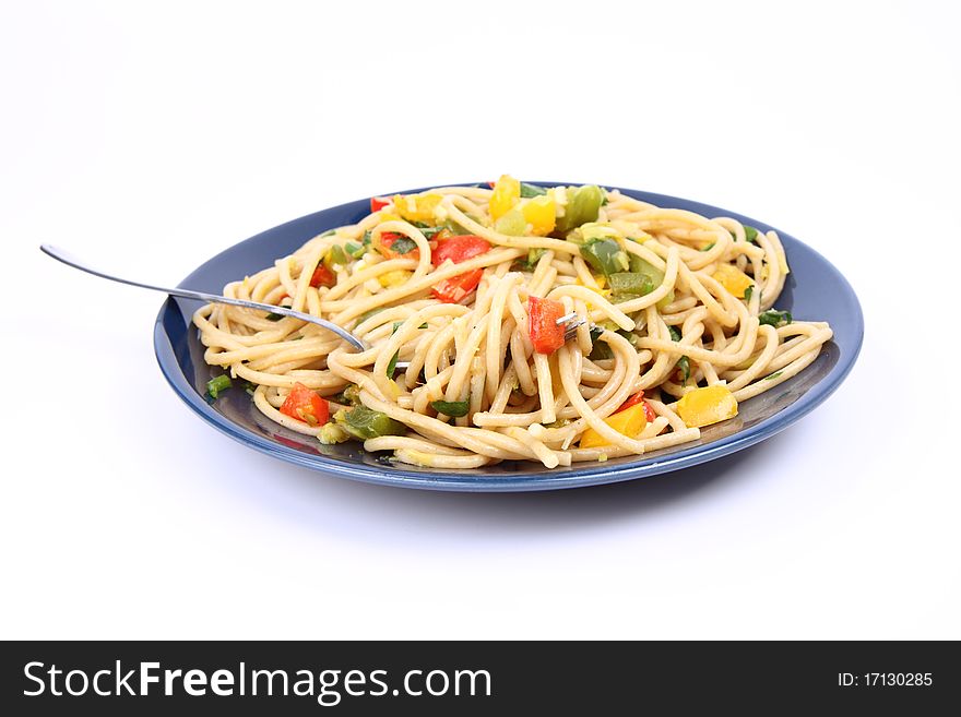 Spaghetti with vegetables being eaten with a fork on white background