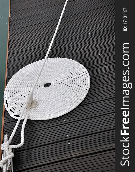 Rope of boat twist on dock board, as a circle, shown as maritime activities, sport or entertainment on sea. Rope of boat twist on dock board, as a circle, shown as maritime activities, sport or entertainment on sea.