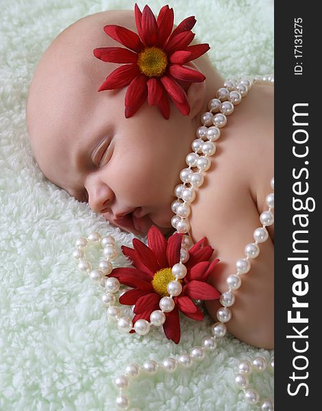 Beautiful newborn baby girl with flowers and pearls. Beautiful newborn baby girl with flowers and pearls