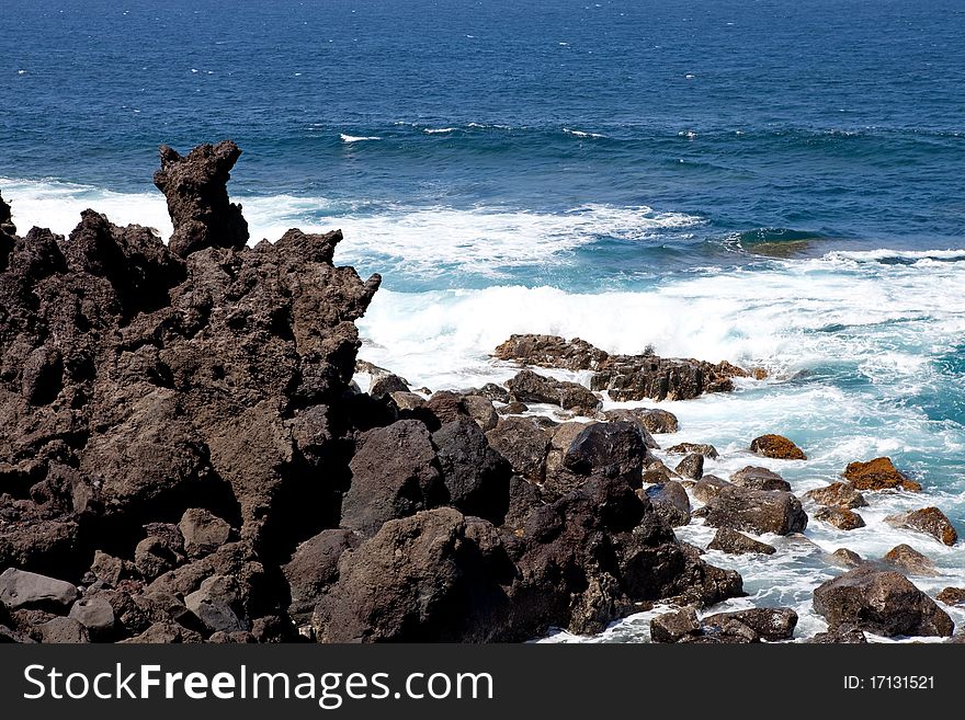 Lanzarote coastline, black rocks on blue sea background, Spain