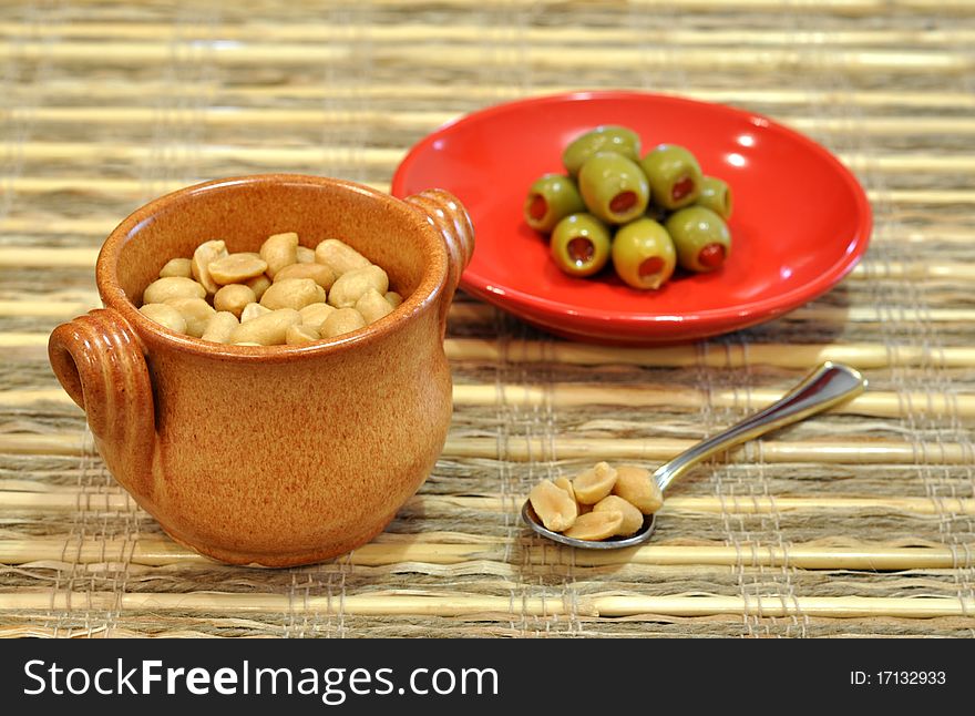 Pot of peanuts and stuffed olives as aperitif