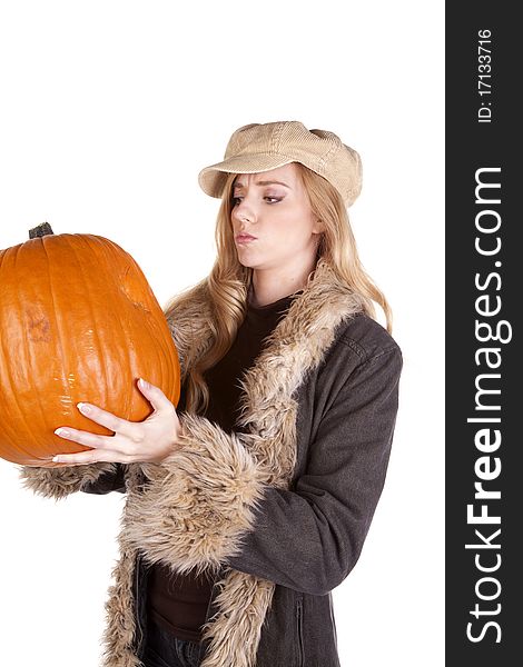 A woman holding and looking at a big pumpkin wondering what to do with it. A woman holding and looking at a big pumpkin wondering what to do with it.