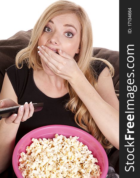 A woman sitting on a bean bag while she is enjoying her popcorn while she is watching tv. A woman sitting on a bean bag while she is enjoying her popcorn while she is watching tv