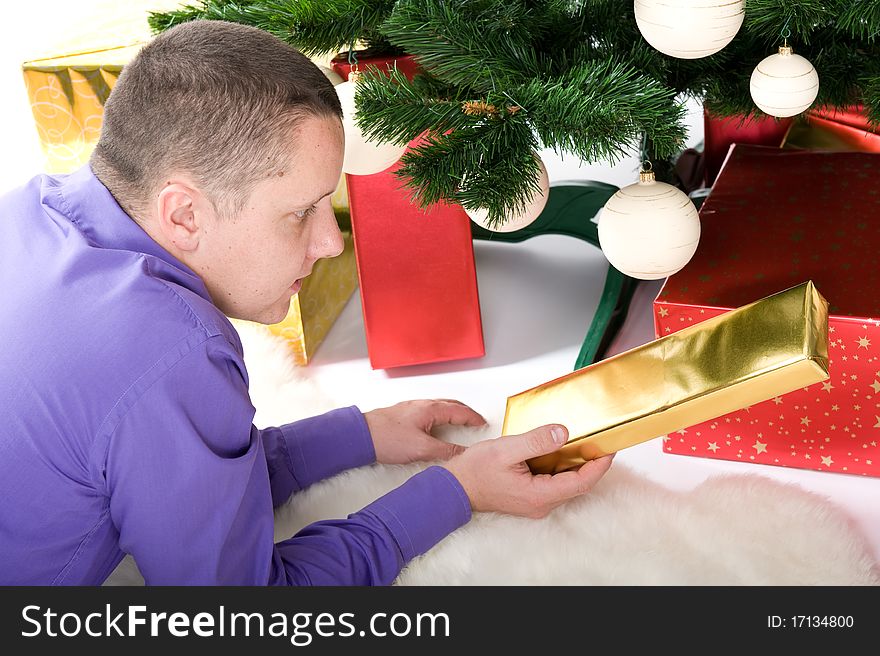 Man with gifts under christmas tree. Man with gifts under christmas tree