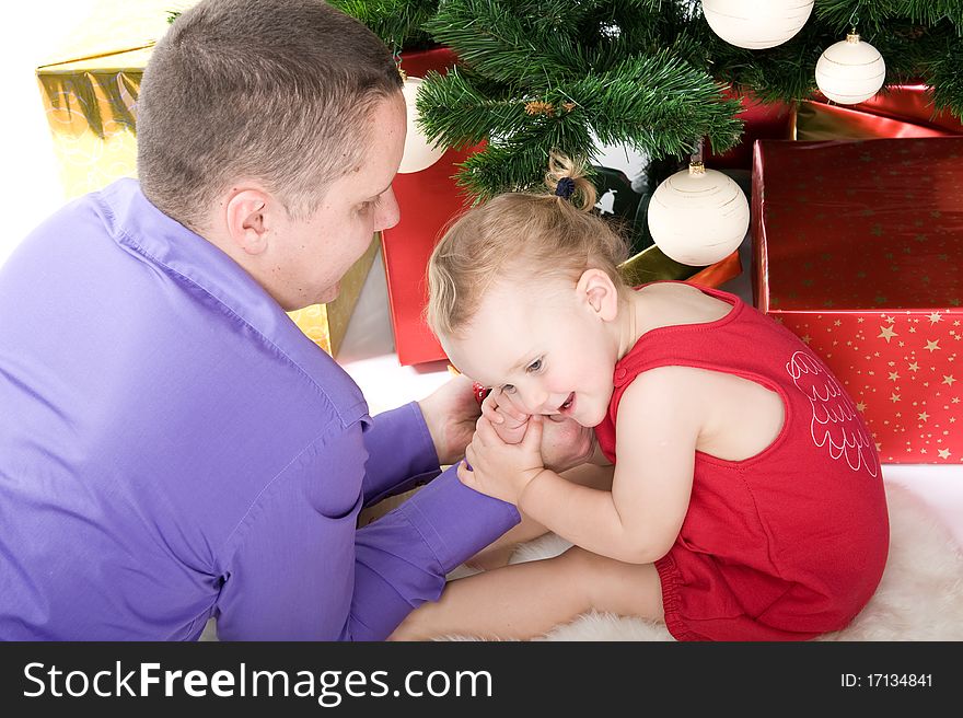 Man with baby under christmas tree