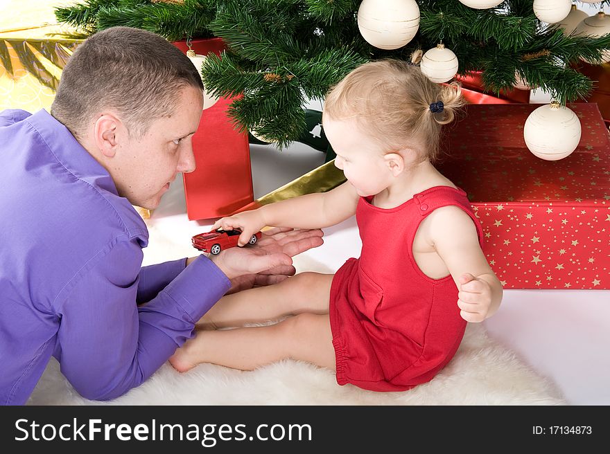 Man with baby under christmas tree