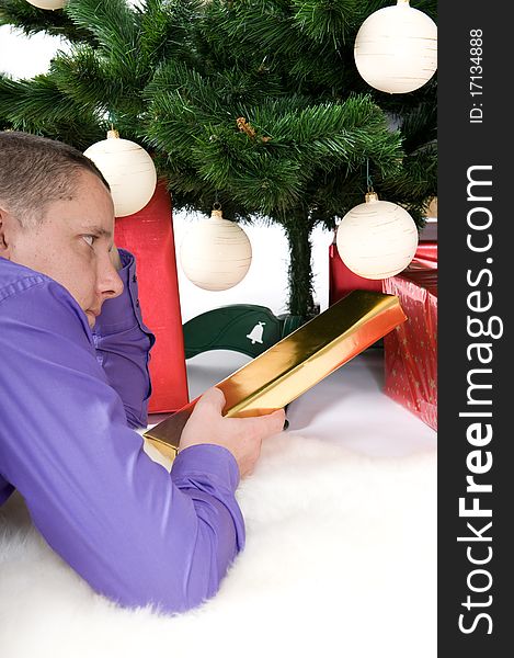 Man with gifts under christmas tree. Man with gifts under christmas tree