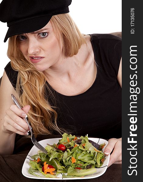 A woman sitting on a bean bag while she is showing a yucky face. She doesn't like her salad. A woman sitting on a bean bag while she is showing a yucky face. She doesn't like her salad.