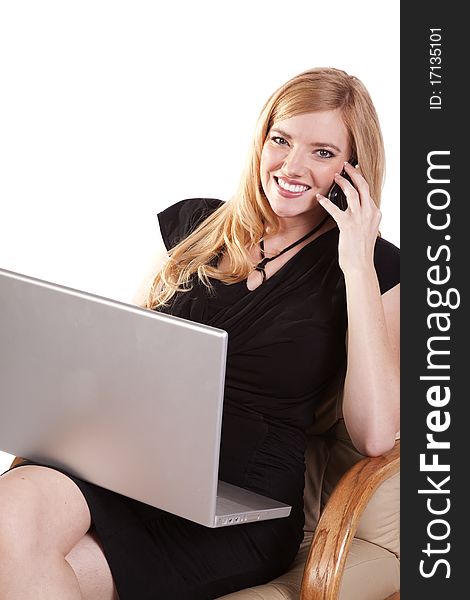 A business woman listening to a call on her cell while she is working on her laptop. A business woman listening to a call on her cell while she is working on her laptop.