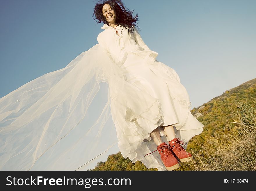 Portrait of romantic woman jumping on field