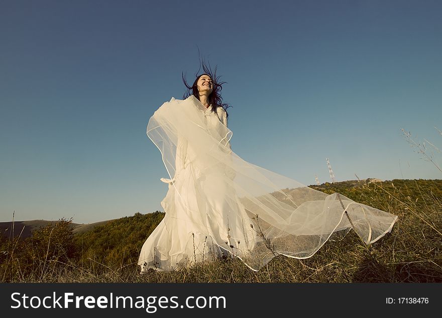 Portrait of romantic woman jumping on field