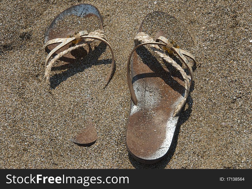 Women sandals abandoned on a beach