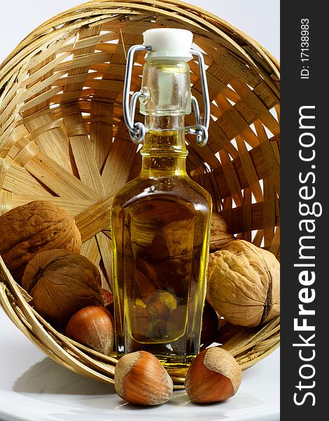 Basket of walnuts and hazelnuts with a bottle of oil