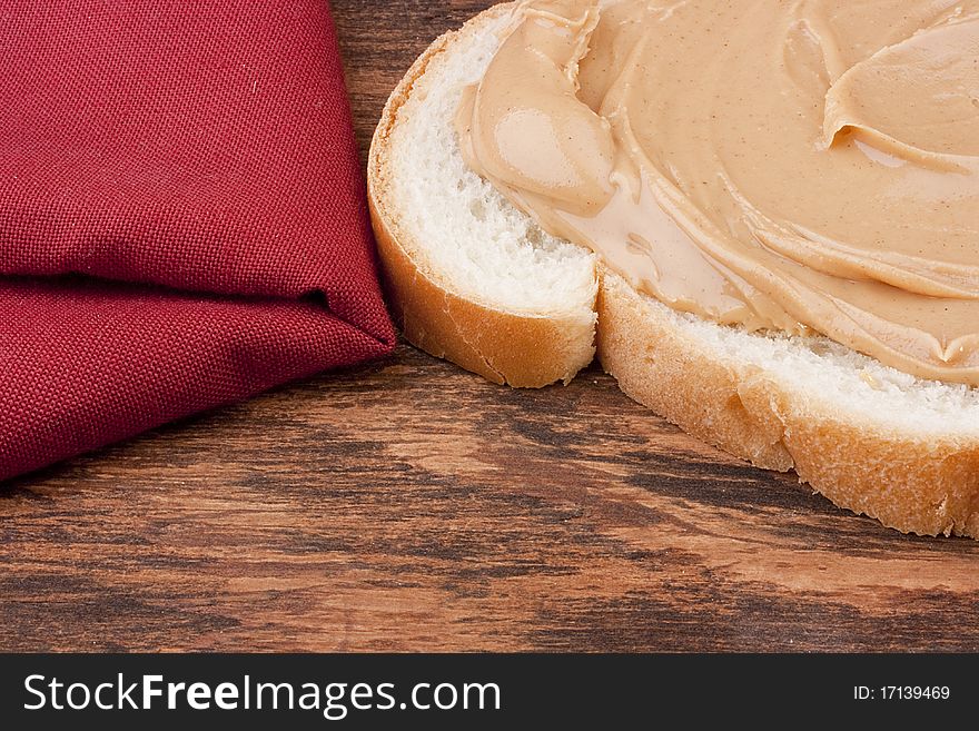 Bread is smeared Peanut butter - a component for a sweet sandwich.