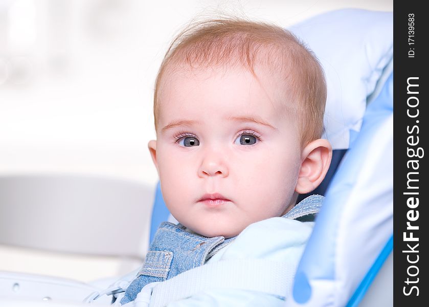 Closeup face of a beautiful baby sitting in chair indoors. Closeup face of a beautiful baby sitting in chair indoors