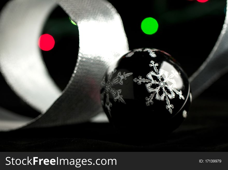 Black christmas ball and colorful lights on the black background. Black christmas ball and colorful lights on the black background