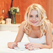 Portrait Of Beautiful Young Woman With Cup On Bed Royalty Free Stock Photo