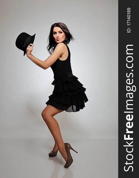 Beautiful fashion dancing woman in black dress with evening make-up and hat. Beautiful fashion dancing woman in black dress with evening make-up and hat