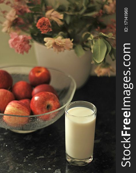 A bowl of apples and a glass of milk shot in natural light. A bowl of apples and a glass of milk shot in natural light
