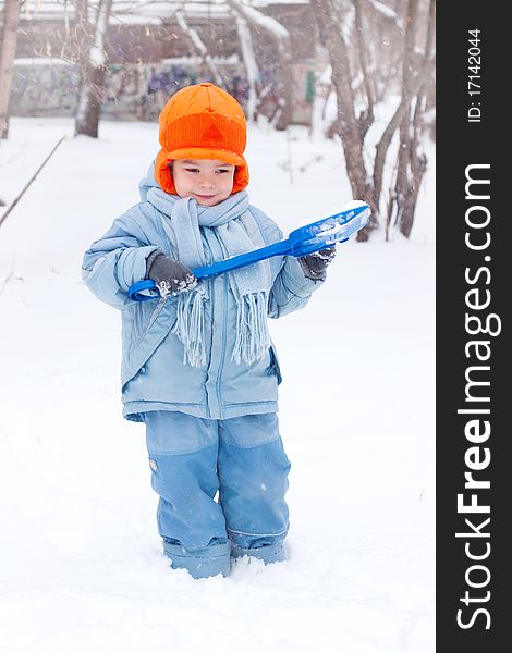 Little boy playing snowballs; snowman sculpts; digs snow. Little boy playing snowballs; snowman sculpts; digs snow