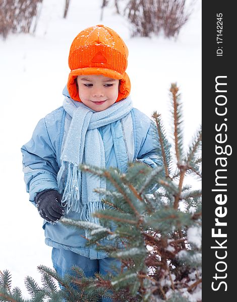 Little boy playing snowballs; snowman sculpts; digs snow