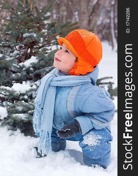 Little boy playing snowballs; snowman sculpts; digs snow