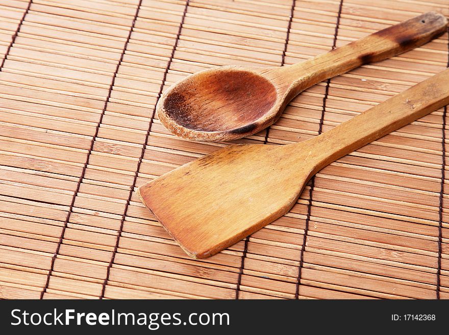 Wooden spoons used and burned over bamboo sticks table