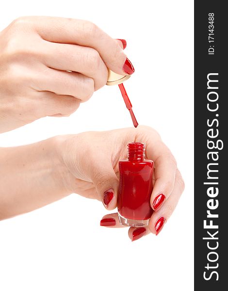 Women's hands with a bottle of red nail polish